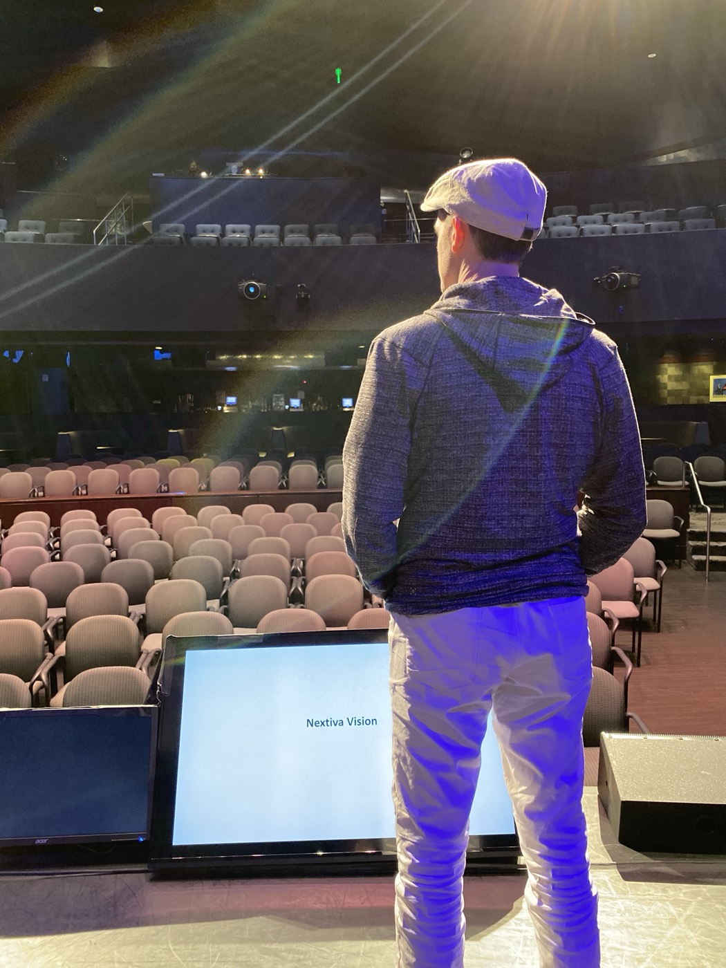 Matthew Dearing at center stage in a large venue, facing the seats before a keynote.